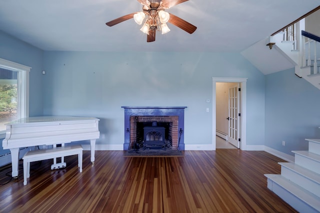 misc room featuring a wood stove, lofted ceiling, ceiling fan, and dark hardwood / wood-style floors