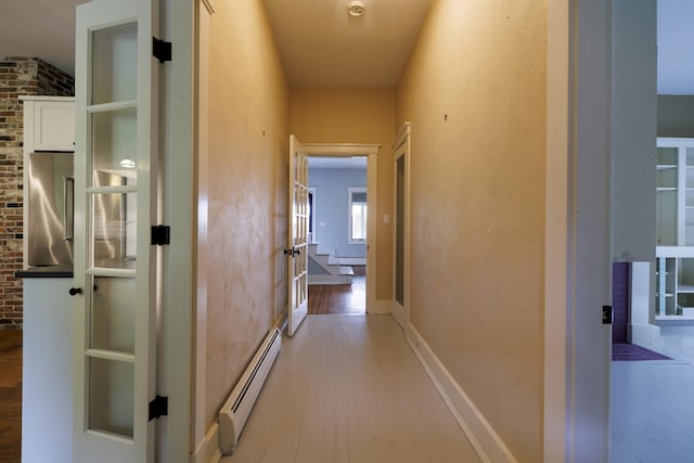 hall with baseboard heating and wood finished floors