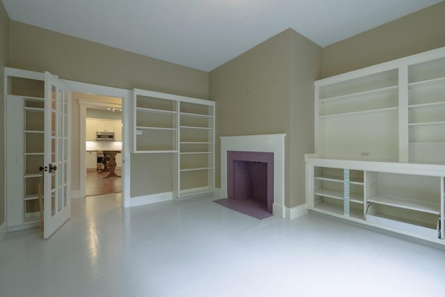 unfurnished living room with french doors and a fireplace with flush hearth