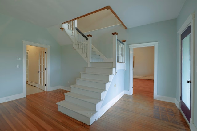 stairs featuring a baseboard heating unit and hardwood / wood-style flooring