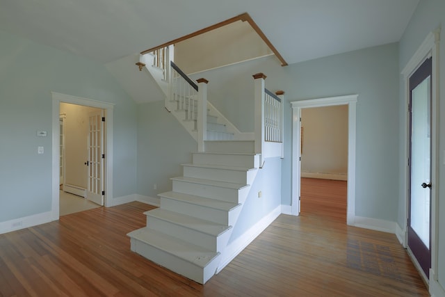 staircase featuring baseboard heating, baseboards, french doors, and wood finished floors