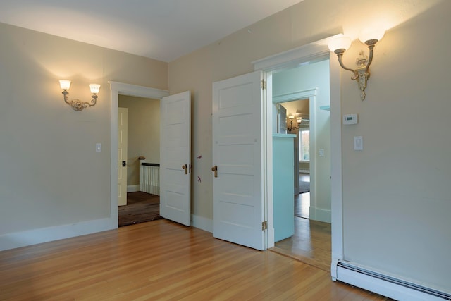 interior space with baseboard heating and light hardwood / wood-style flooring