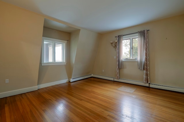 unfurnished room with a baseboard radiator and light hardwood / wood-style floors