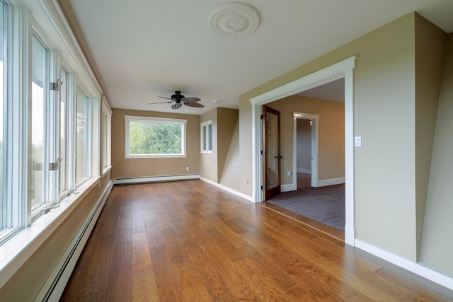 empty room featuring light hardwood / wood-style flooring, a baseboard heating unit, and ceiling fan