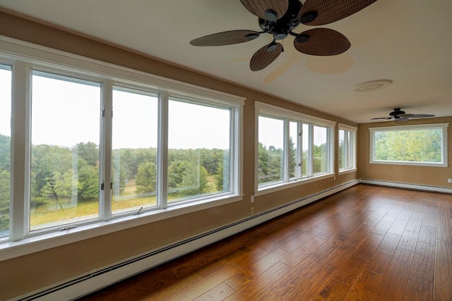 unfurnished sunroom with ceiling fan, a baseboard heating unit, and a wealth of natural light