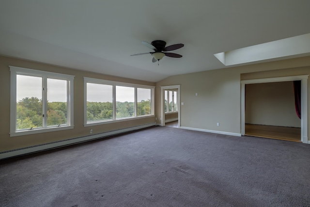 empty room featuring dark carpet, a ceiling fan, a baseboard heating unit, lofted ceiling, and baseboards