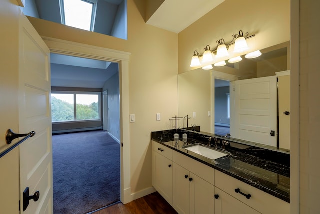 bathroom featuring lofted ceiling, vanity, and hardwood / wood-style flooring