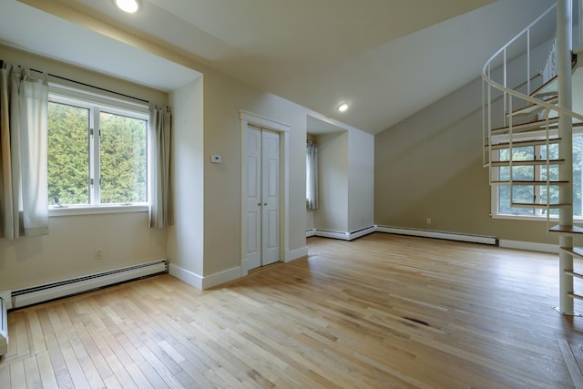 interior space with stairs, baseboard heating, and light wood-type flooring