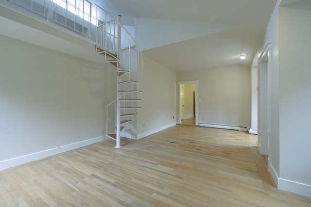unfurnished living room with stairway, baseboard heating, wood finished floors, a high ceiling, and baseboards
