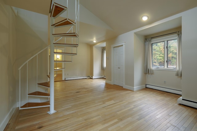 interior space with stairway, light wood-style flooring, a baseboard radiator, and baseboards