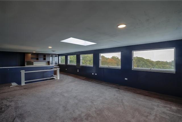 unfurnished living room with recessed lighting, carpet, and a skylight