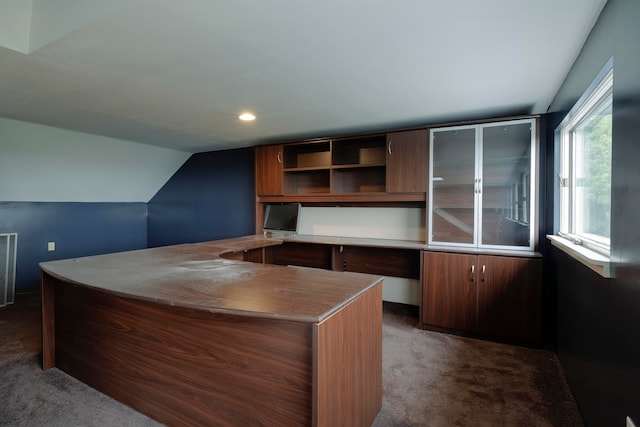 carpeted home office with vaulted ceiling