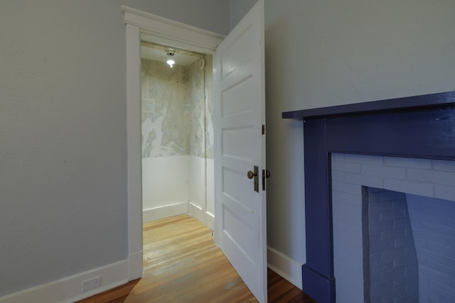 room details with baseboards, wood finished floors, and a fireplace