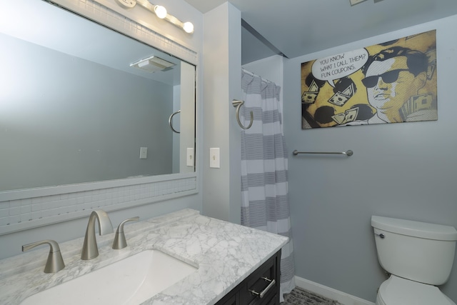 bathroom featuring toilet, vanity, and baseboards
