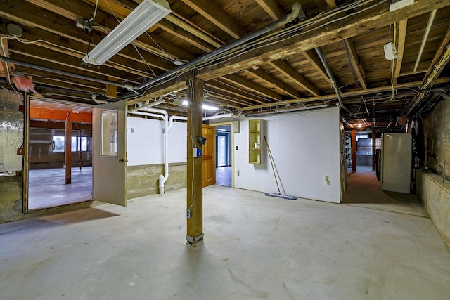 below grade area featuring freestanding refrigerator