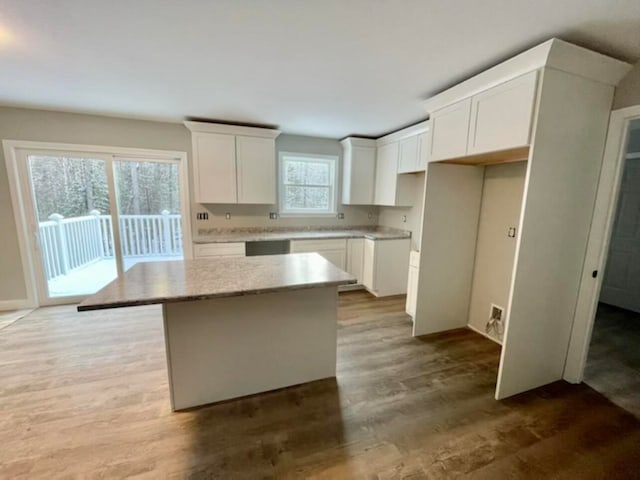 kitchen featuring hardwood / wood-style flooring, white cabinetry, a healthy amount of sunlight, and a center island