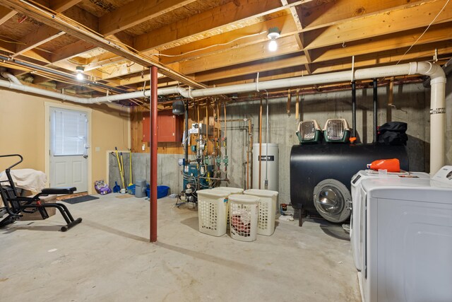 unfinished basement featuring washer and dryer, gas water heater, a heating unit, and heating fuel