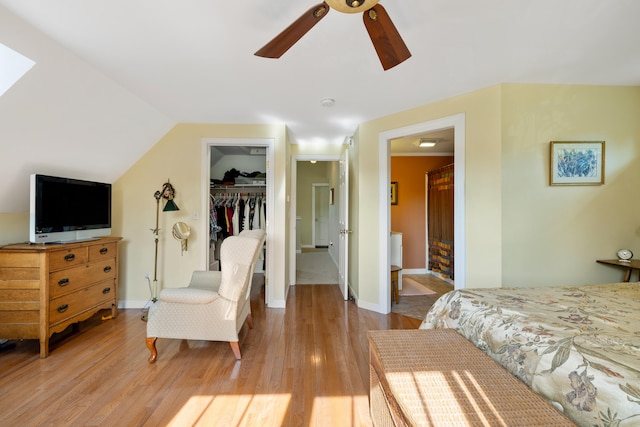 bedroom featuring lofted ceiling, connected bathroom, light wood-style flooring, a spacious closet, and a closet