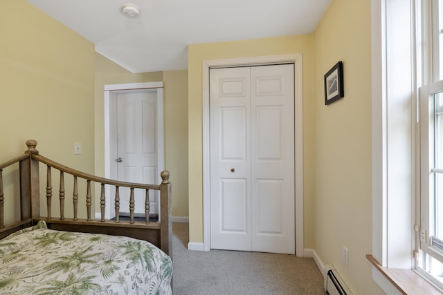 carpeted bedroom featuring a closet and baseboards