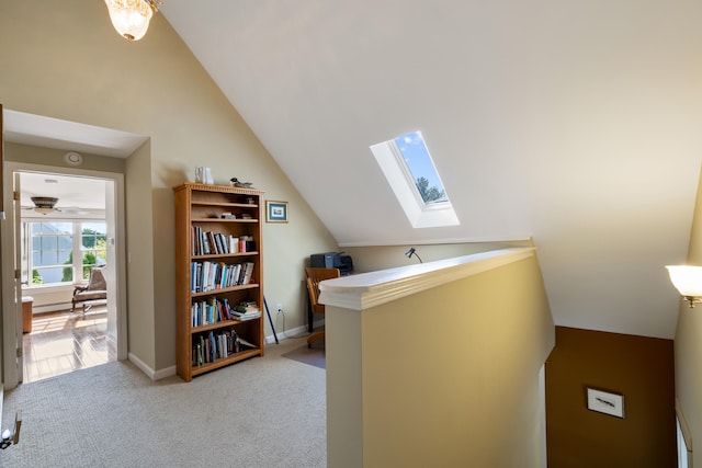 bonus room featuring vaulted ceiling with skylight, light carpet, and baseboards