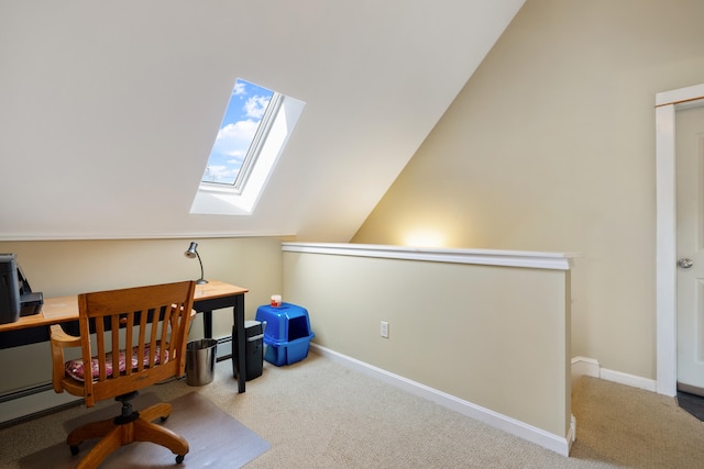 carpeted office space with vaulted ceiling with skylight and baseboards