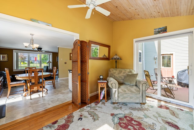 sitting room with lofted ceiling, wood ceiling, wood finished floors, baseboards, and ceiling fan with notable chandelier