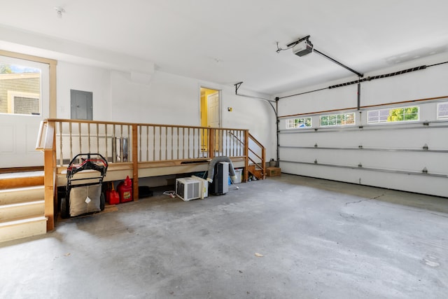 garage with a garage door opener and electric panel