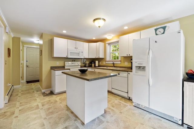 kitchen with white appliances, dark countertops, a kitchen island, baseboard heating, and white cabinetry