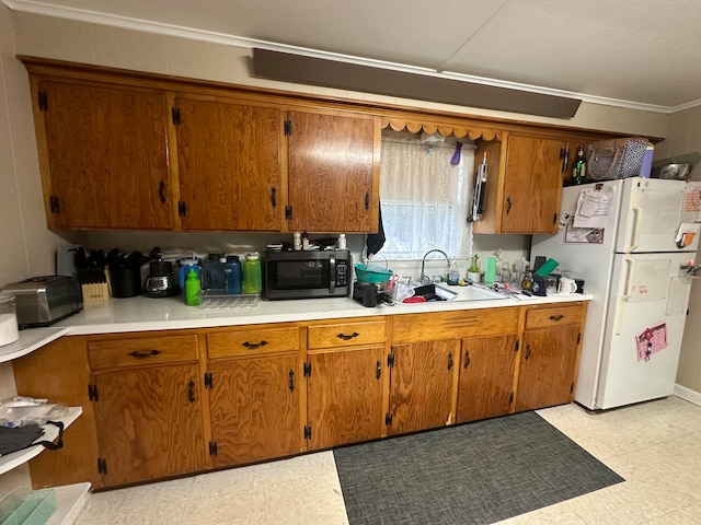 kitchen featuring sink, crown molding, and white fridge