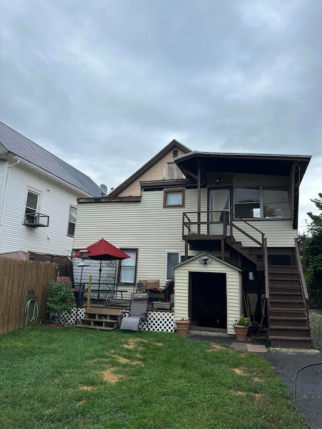 rear view of property featuring a deck and a yard