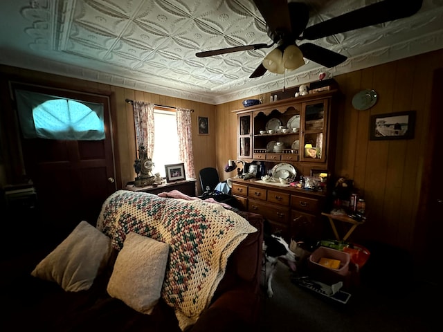 bedroom featuring ceiling fan and wood walls