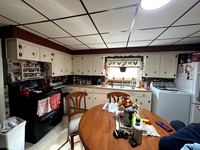 kitchen featuring white cabinetry, black range with electric stovetop, white fridge, a paneled ceiling, and sink