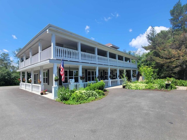 back of property featuring a balcony and a porch