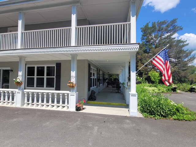 entrance to property featuring a balcony and a porch