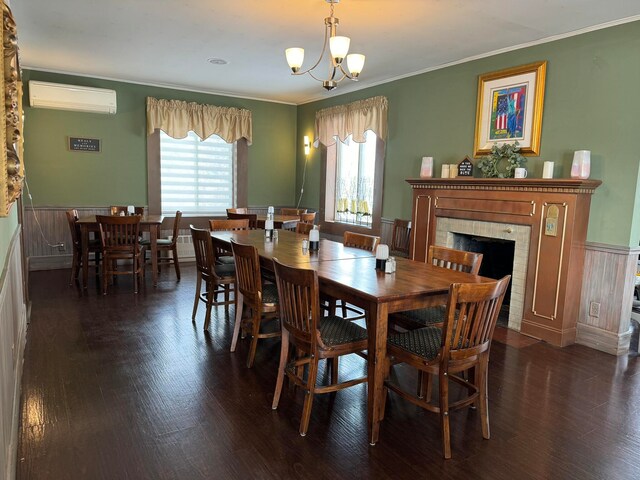 dining room with dark hardwood / wood-style floors, an AC wall unit, a tiled fireplace, and an inviting chandelier