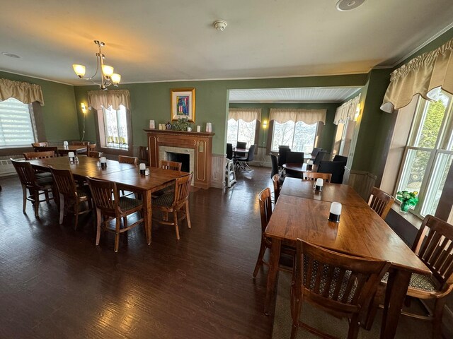 dining space with an inviting chandelier, dark hardwood / wood-style floors, and ornamental molding