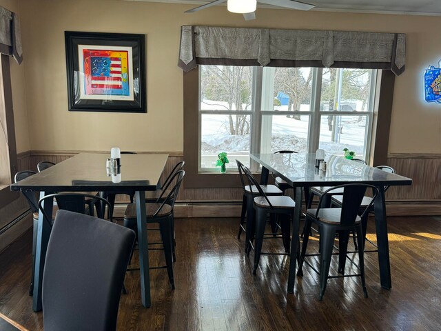 dining space featuring wood walls, dark hardwood / wood-style flooring, and ceiling fan