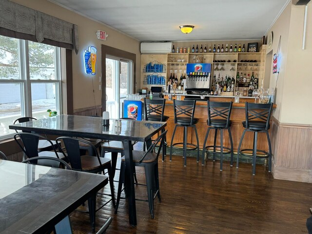 dining room with crown molding, an AC wall unit, dark hardwood / wood-style floors, and indoor bar