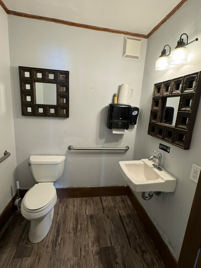 bathroom with ornamental molding, hardwood / wood-style flooring, sink, and toilet