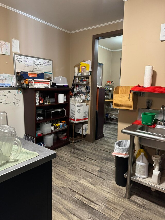 office with ornamental molding, wood-type flooring, and sink