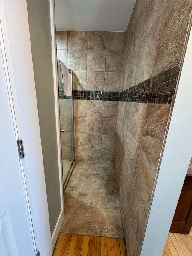 bathroom with an enclosed shower and hardwood / wood-style flooring