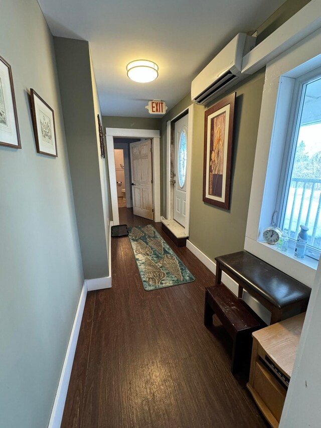 hall featuring dark hardwood / wood-style flooring and an AC wall unit