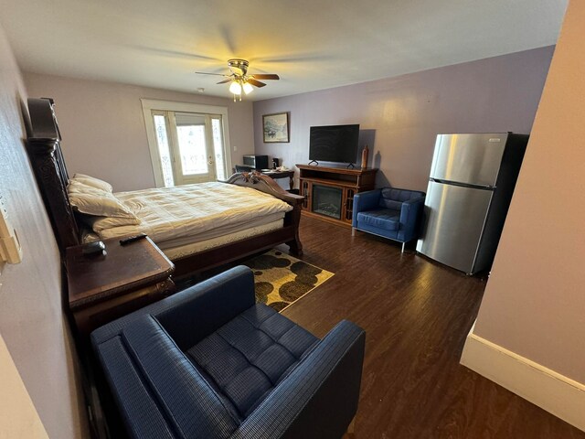 bedroom with ceiling fan, stainless steel refrigerator, and dark wood-type flooring