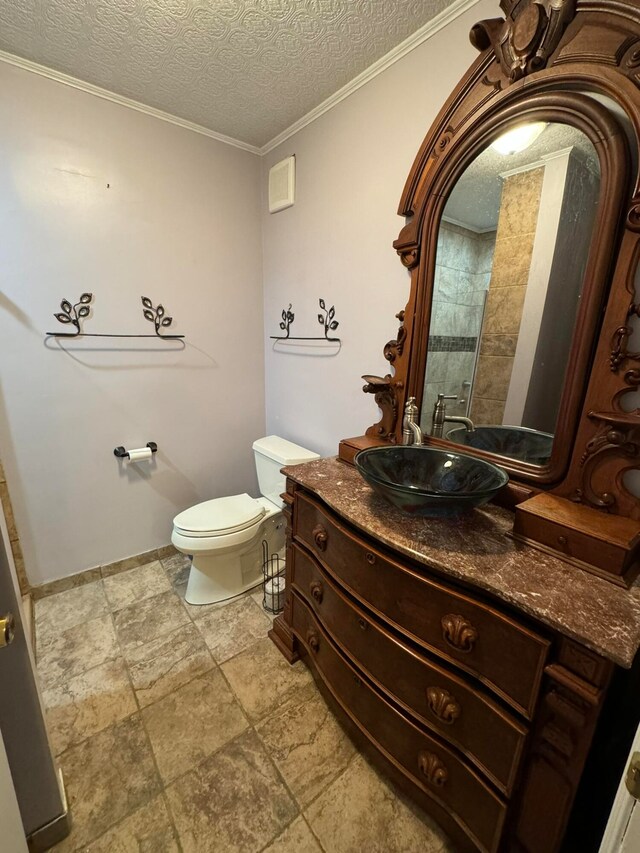 bathroom featuring ornamental molding, a textured ceiling, vanity, and toilet