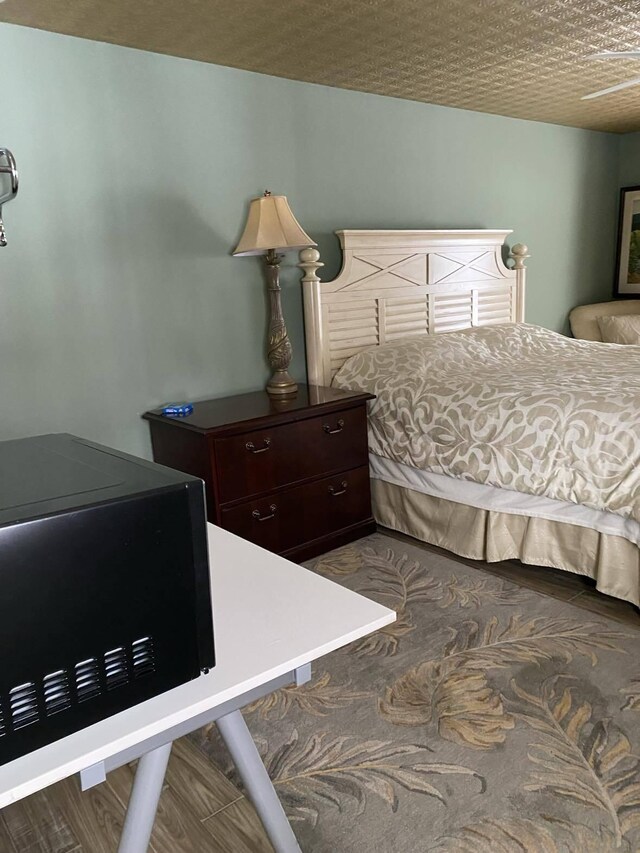 bedroom featuring a textured ceiling and hardwood / wood-style floors