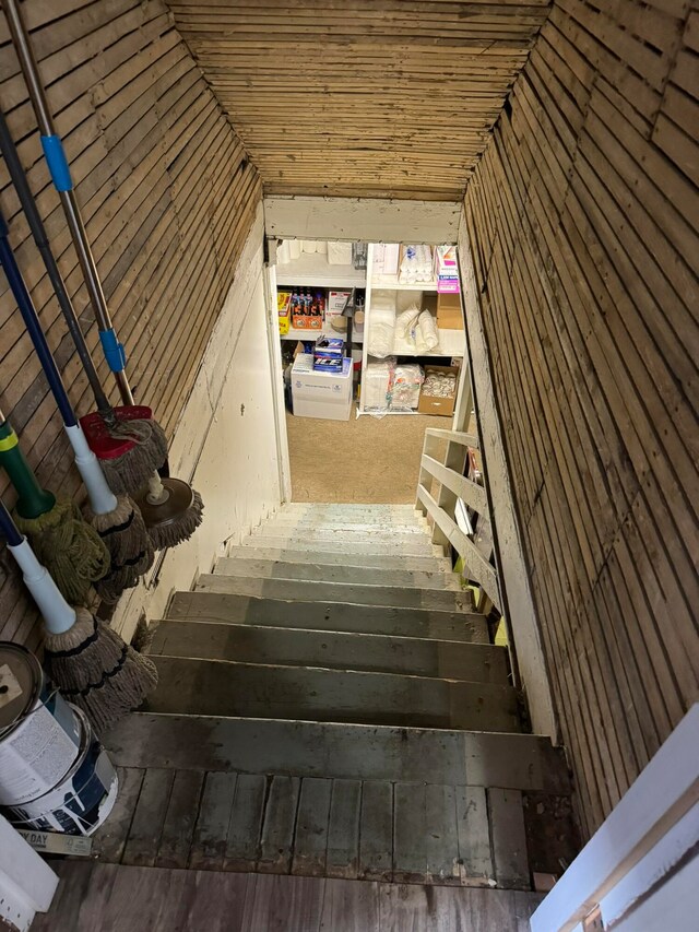 stairway featuring wood-type flooring and vaulted ceiling