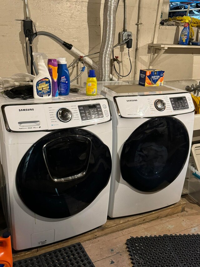 laundry area featuring wood-type flooring and washer and dryer