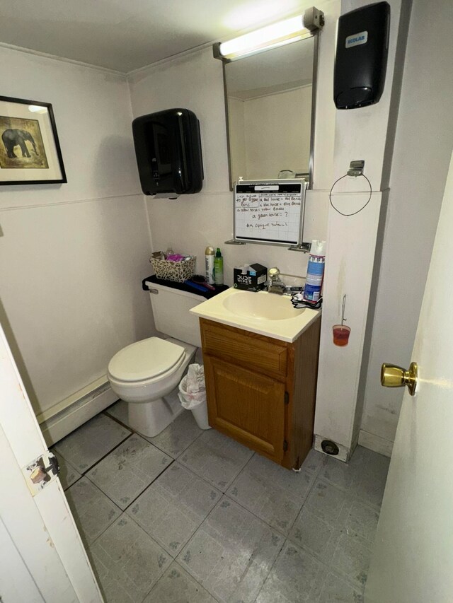 bathroom with a baseboard heating unit, vanity, and toilet