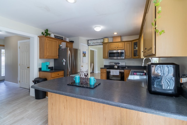 kitchen with appliances with stainless steel finishes, kitchen peninsula, and sink