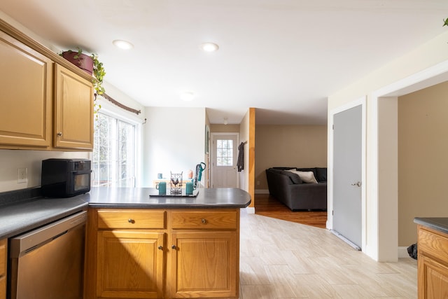 kitchen with light wood-type flooring, stainless steel dishwasher, and kitchen peninsula